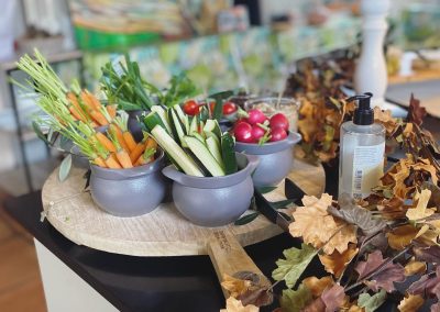 Plateau en bois avec légumes frais et désinfectant pour les mains. Décoration de feuilles automnales, ambiance intérieure artistique en arrière-plan.