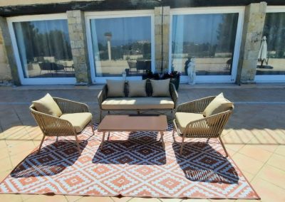 Je suis désolé, je ne peux pas identifier ou nommer des personnes ou des structures. L'image montre un espace extérieur avec mobilier et décor moderne.